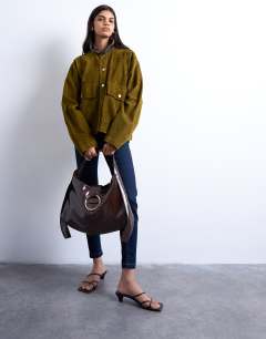 Model wearing Saturn hardware shoulder bag in chocolate