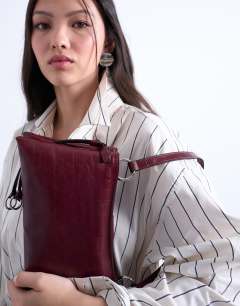 Model wearing Saxon textured shoulder bag in burgundy
