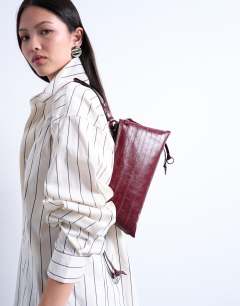 Model wearing Saxon textured shoulder bag in burgundy