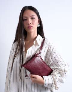 Model wearing Saxon textured shoulder bag in burgundy