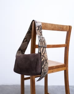 Model wearing Scarlett real leather suede shoulder bag with contrast strap in chocolate and snake