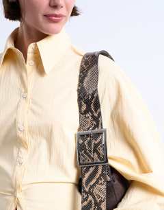 Model wearing Scarlett real leather suede shoulder bag with contrast strap in chocolate and snake