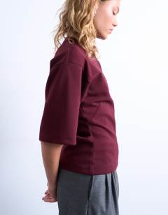 Model wearing Scuba-style fabric cinch short sleeve tee in burgundy