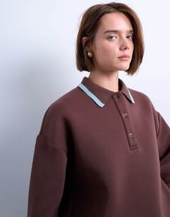 Model wearing Scuba-style fabric knit collar piped polo sweat in chocolate brown