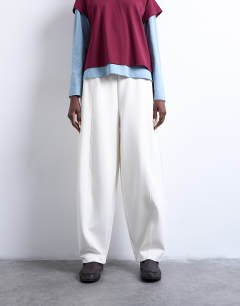 Model wearing Scuba-style fabric pintuck barrel leg jogger in ecru