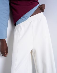 Model wearing Scuba-style fabric pintuck barrel leg jogger in ecru