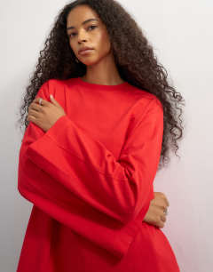 Model wearing Seamed detail long sleeve skater top in red