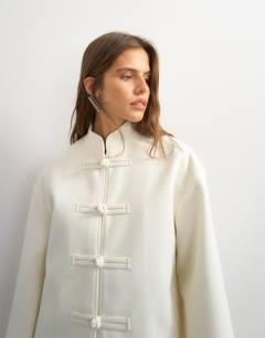 Model wearing Self frogging formal blazer coat in ecru