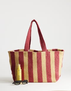 Model wearing Selia large stripe straw tote bag in red & pink