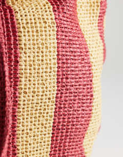 Model wearing Selia large stripe straw tote bag in red & pink