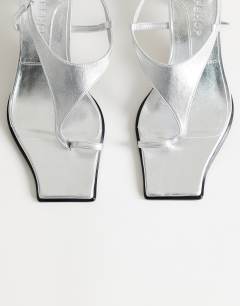 Model wearing Selina tie up mid heeled sandal with toe loop in silver