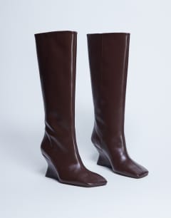 Model wearing Selma Premium leather knee high wedge boot in chocolate