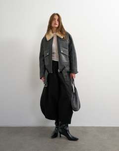 Model wearing Shearling belted biker jacket in black and cream