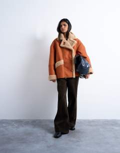 Model wearing Shearling oversized car coat in tan and cream