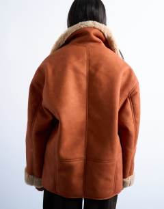 Model wearing Shearling oversized car coat in tan and cream