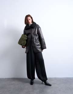 Model wearing Shearling oversized patch pocket mid length funnel neck car coat in black
