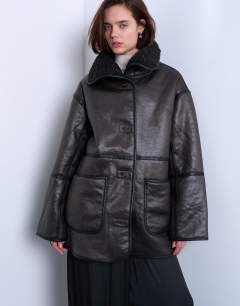 Model wearing Shearling oversized patch pocket mid length funnel neck car coat in black