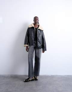 Model wearing Shearling oversized reversible coat with button loop in black and cream