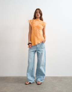 Model wearing Sheer drape neck top in rust