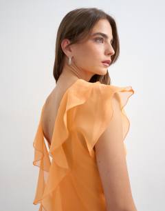Model wearing Sheer drape neck top in rust