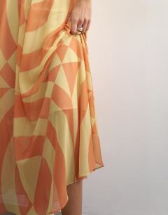 Model wearing Sheer full circle chiffon midi skirt in orange abstract print