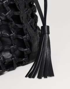 Model wearing Shia medium woven shoulder bag in black