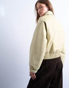 Model wearing Short bubble faux leather bomber jacket in buttermilk