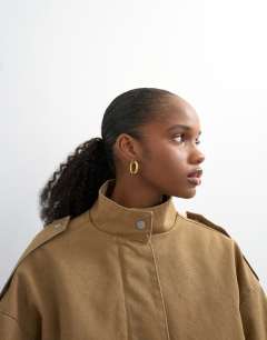 Model wearing Short cotton belted bomber jacket in tan