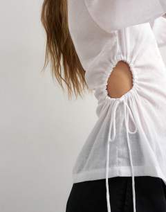 Model wearing Short sleeve fitted shirt with gathered waist in white