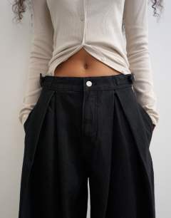 Model wearing Side buckle wide leg mid rise jean in clean black