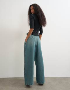 Model wearing Side buckle wide leg mid rise jean in green cast