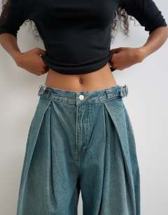 Model wearing Side buckle wide leg mid rise jean in green cast