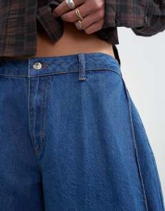 Model wearing Side pleat cocoon jean in rich blue