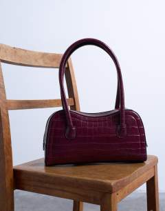 Model wearing Simba structured shoulder bag in burgundy croc