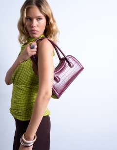 Model wearing Simba structured shoulder bag in burgundy croc