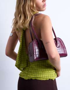 Model wearing Simba structured shoulder bag in burgundy croc