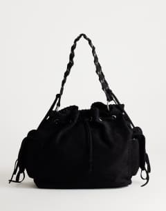 Model wearing Simone suedette pocket detail bucket shoulder bag in black