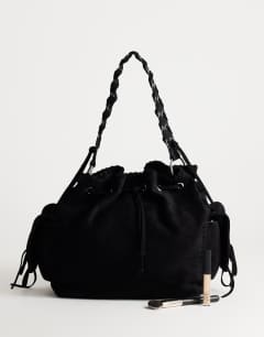 Model wearing Simone suedette pocket detail bucket shoulder bag in black