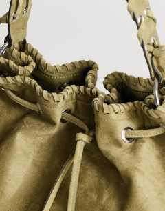 Model wearing Simone suedette pocket detail bucket shoulder bag in khaki