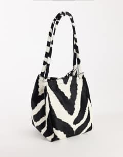 Model wearing Singer medium real hair on leather shoulder bag in zebra