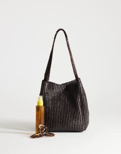 Model wearing Singer medium weave shoulder bag in chocolate