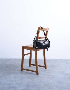 Model wearing Siris medium buckle shoulder bag in black