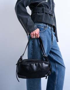 Model wearing Siris medium buckle shoulder bag in black