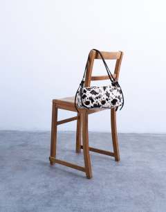 Model wearing Siris medium buckle shoulder bag in cow print