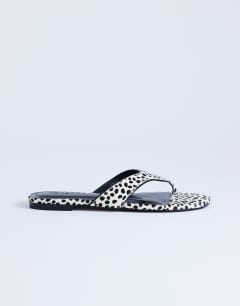 Model wearing Sisi toe thong flat sandal in dalmatian print hair on real leather