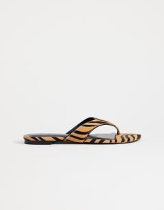 Model wearing Sisi toe thong flat sandal in tiger print hair on real leather