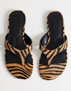 Model wearing Sisi toe thong flat sandal in tiger print hair on real leather
