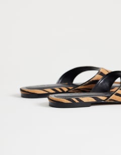 Model wearing Sisi toe thong flat sandal in tiger print hair on real leather