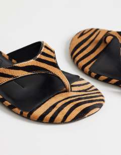 Model wearing Sisi toe thong flat sandal in tiger print hair on real leather