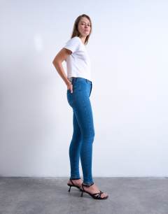 Model wearing Skinny high rise jean in vintage blue